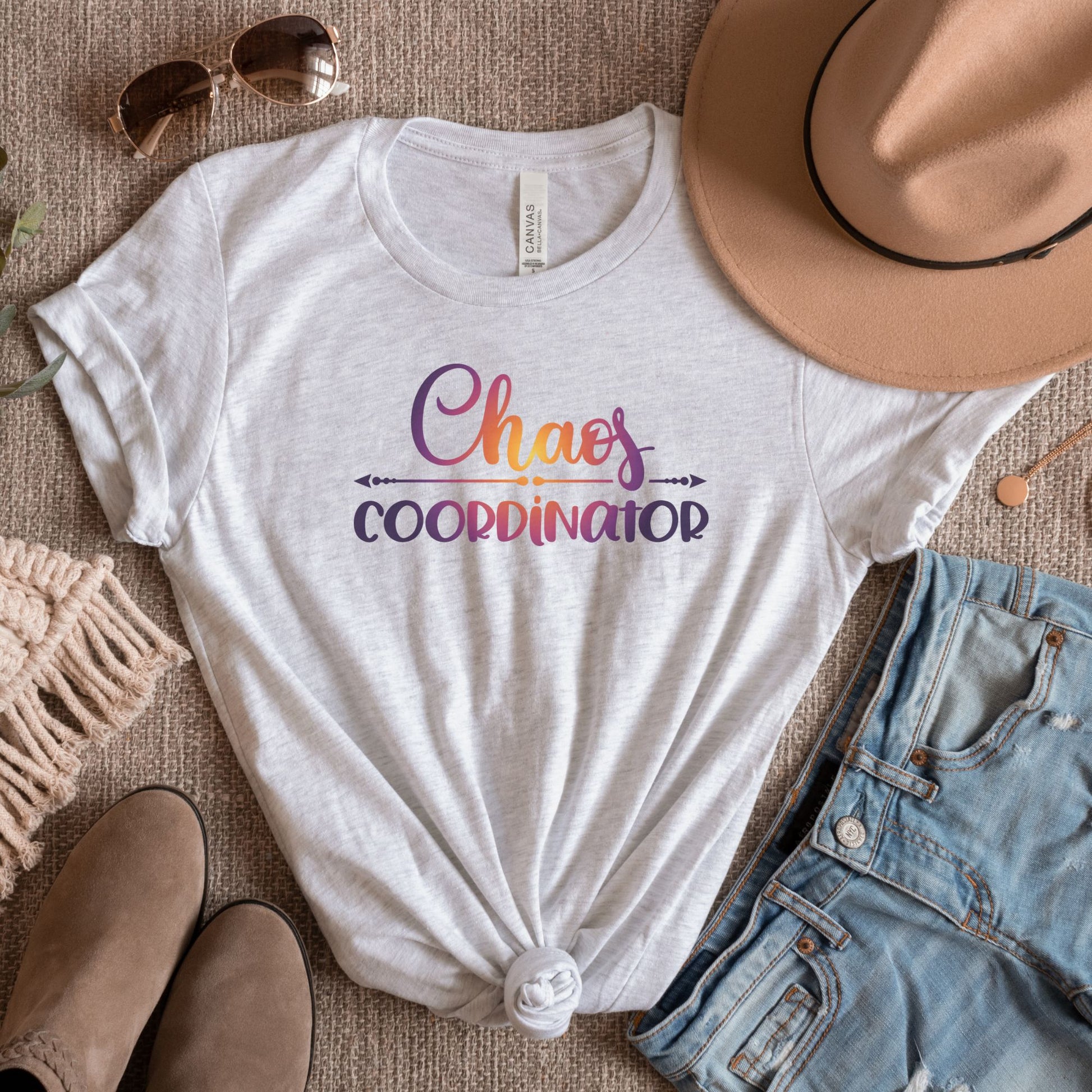 Flat lay of Ash color tee with text Chaos Coordinator in center written in multicolored text