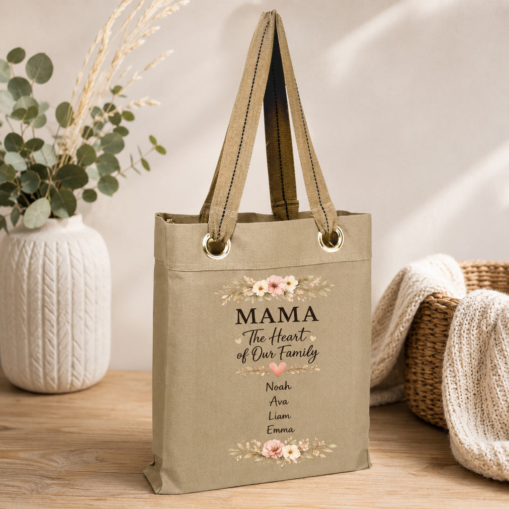 Beige tote bag with 'MAMA The Heart of Our Family' text and floral designs and kids names on a wooden surface.