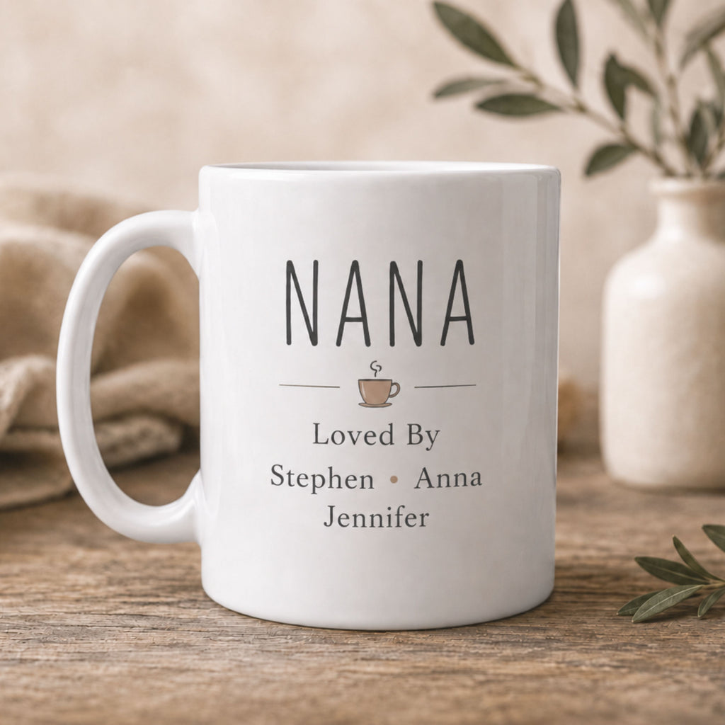 White mug with 'Nana' and grand kids names printed on it, placed on a wooden surface with a neutral background.