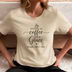 Person wearing a natural t-shirt with 'Running on Coffee and Grace' text with kids names sitting on floor by bed.