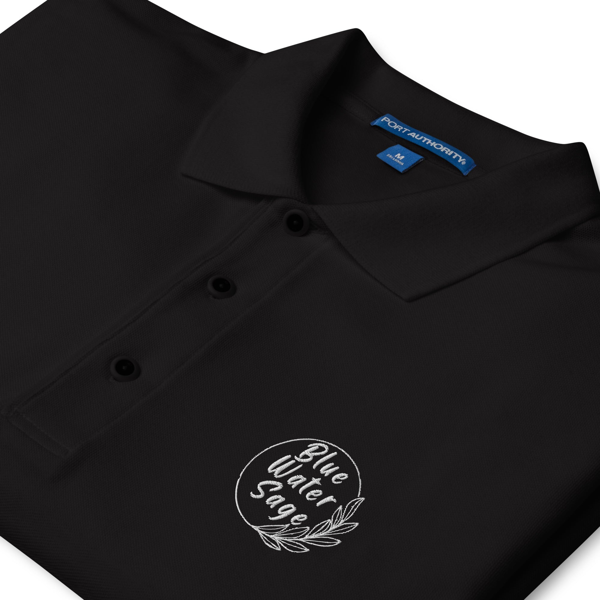 Black polo shirt with a logo and Port Authority label on a white background